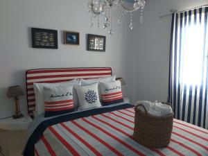 um quarto com uma cama com lençóis e almofadas listradas em Yacht Marine Maison em Naxos Chora