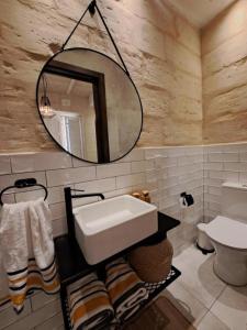 La salle de bains est pourvue d'un lavabo et d'un miroir. dans l'établissement Ta' Wenzu, à Il-Birgu