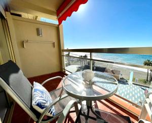 una mesa de cristal y sillas en un balcón con vistas al océano. en Apartahotel CHINASOL con Parking y Desayuno, en Almuñécar
