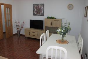 a dining room with a white table and a television at Casa Mirasierra in Mota del Cuervo
