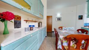 uma cozinha com uma mesa com um vaso de flores em House Azzurra by Holiday World em Gênova