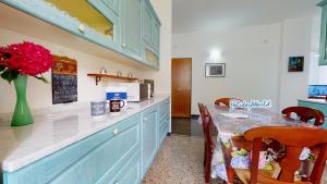 a kitchen with a table with a vase of flowers at House Azzurra by Holiday World in Genova