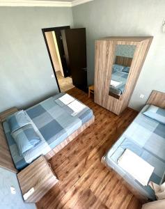 a bedroom with two beds and a mirror at Rio cottage apartment in Ureki