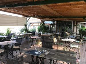 eine leere Terrasse mit Tischen und Stühlen in einem Restaurant in der Unterkunft Hôtel Le Floride 