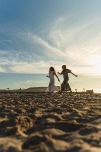a bride and groom running on the beach at Selina Dakhla in Dakhla