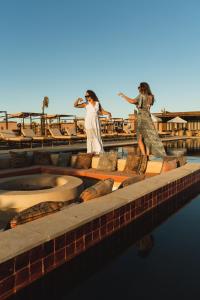 two statues of women standing on a dock in the water at Selina Dakhla in Dakhla