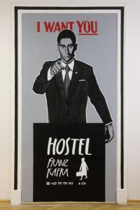 un póster de un hombre en esmoquin en Hostel Franz Kafka, en Praga