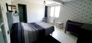 um quarto com uma cama, uma janela e uma televisão em L'osmose em Coulogne