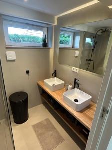 een badkamer met 2 wastafels en een spiegel bij Leef Zuiden in Simpelveld