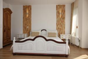 ein Schlafzimmer mit einem weißen Bett und zwei Nachttischen in der Unterkunft Стаи за гости RADEA in Dewin
