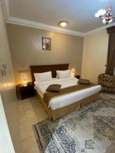 1 dormitorio con 1 cama grande y 1 silla en Hayat Redwa Hotel, en Yanbu