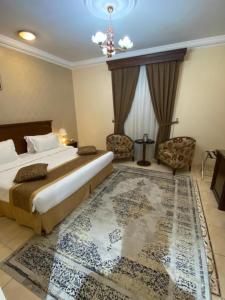 - une chambre avec un lit et un grand tapis dans l'établissement Hayat Redwa Hotel, à Yanbu