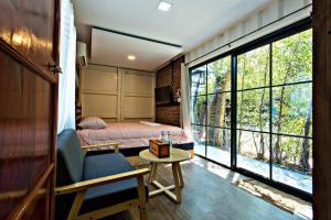 a bedroom with a bed and a table and a window at 99/9 Box Resort in Ban Hua Saphan