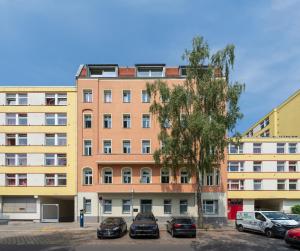 ein hohes Gebäude mit Autos auf einem Parkplatz in der Unterkunft BENSIMON apartments Mitte/Wedding in Berlin