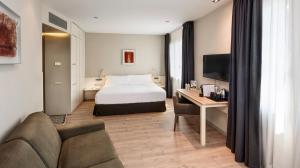 a hotel room with a bed and a couch at Sercotel Amister Art Hotel Barcelona in Barcelona