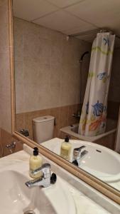 a bathroom with a sink and a mirror and a toilet at Apartamento en Calpe, edf. Coral Beach in Calpe