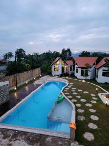 a swimming pool in the yard of a house at LA PETITE MANGROVE Resort in Phumĭ Srângam