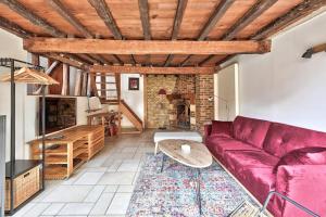 a living room with a red couch and a table at Maison de ville spacieuse et calme en plein coeur d'Amiens in Amiens