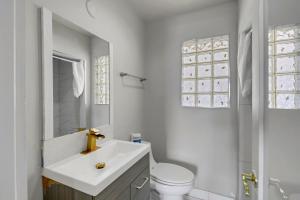 a white bathroom with a sink and a toilet at Desert Moon Motel in Las Vegas