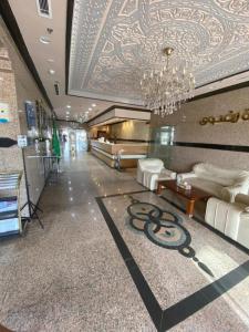 eine Lobby mit einem Kronleuchter und weißen Sofas in der Unterkunft Hayat Redwa Hotel in Yanbu