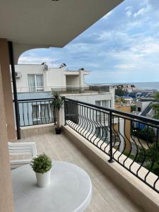 een balkon met een tafel en uitzicht op de oceaan bij Antorini Apartments in Sveti Vlas