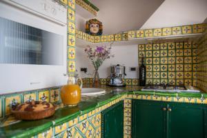 una cocina con azulejos amarillos y verdes en la encimera en B&B Casa Andrea, en Taormina