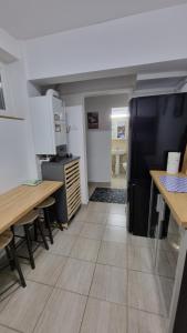 a kitchen with a black refrigerator and wooden tables at Centru 2 in Constanţa