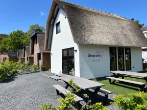 - un bâtiment avec deux tables de pique-nique devant dans l'établissement Loft Heerehof, à Schoorl