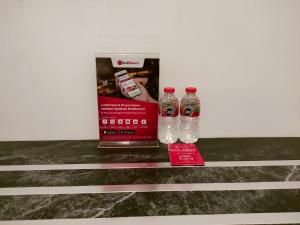 two bottles of water sitting on a counter next to a box at RedDoorz At Sukomanunggal Surabaya in Surabaya