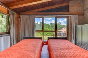 two beds in a bedroom with a large window at 3 Charming Private Home with Pool, BBQ, Wi-Fi & Free Parking in Castel del Piano +29 photos