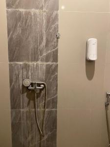 una doccia in bagno con telefono a parete di RedDoorz At Sukomanunggal Surabaya a Surabaya