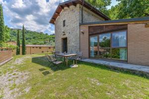 a stone house with a picnic table in the yard at 3 Charming Private Home with Pool, BBQ, Wi-Fi & Free Parking in Castel del Piano