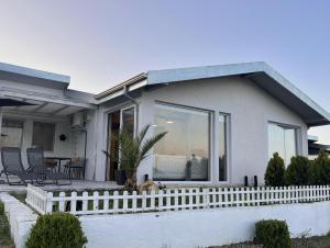 una casa con una recinzione bianca davanti di villas 21,22 Albena sea view a Rogachevo