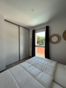 uma cama branca num quarto com uma janela em Villa 4 chbres avec piscine (10) em Saint-Augustin