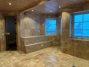 ein großes Bad mit ebenerdiger Dusche neben einem Fenster in der Unterkunft Fjällvidden - lyxig fjällstuga i Idre in Idrefjäll