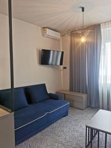 a living room with a blue couch and a tv at Casa Achim in Baia Mare