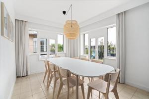 a dining room with a white table and chairs at - Duin 63 - Ruim 8 pers duplex app met terras in Koksijde