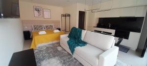 a living room with a white couch and a table at Sargaço Suíte Pool and Beach in Póvoa de Varzim