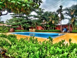 a swimming pool in front of a house at Opulence Beach Resort Awas, Alibaug in Alibaug