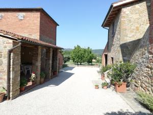 a courtyard of an old stone building with potted plants at Il papavero verde in Lucignano