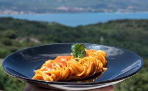 a plate of pasta with tomato sauce and ailantro leaf at Hotel Pedra Santa in Baja Sardinia