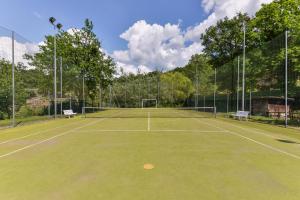 a tennis court with two benches on it at 3 Charming Private Home with Pool, BBQ, Wi-Fi & Free Parking in Castel del Piano