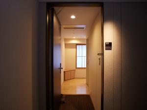 a hallway with a door leading into a room at Kyoto Hot Spring Hatoya Zuihokaku Hotel in Kyoto