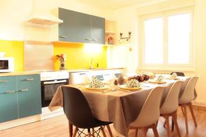 a kitchen with a table and chairs in a kitchen at L'Aparté - Appartement cosy esprit montagne in Bussang