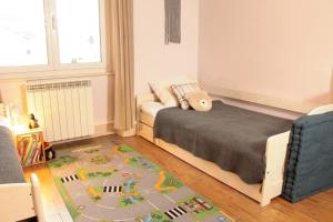 a bedroom with a bed and a toy train rug at L'Aparté - Appartement cosy esprit montagne in Bussang