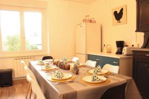 a kitchen with a table with chairs and a refrigerator at L'Aparté - Appartement cosy esprit montagne in Bussang +8 photos