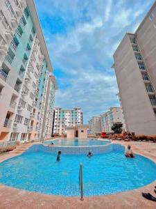 a swimming pool in the middle of two tall buildings at Seawind Condominiums Tower 1,3,4,5 in Davao City