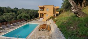 una casa con piscina accanto a un edificio di Villa Kostas-NE Corfu with heated salt swimming pool a Agios Spyridon Corfu