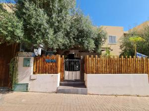 una valla de madera frente a una casa con una puerta en Suite4u en Eilat