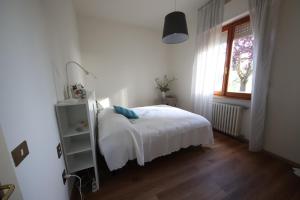 1 dormitorio con cama blanca y ventana en Affittacamere Acquaria-Vinci, en Vinci